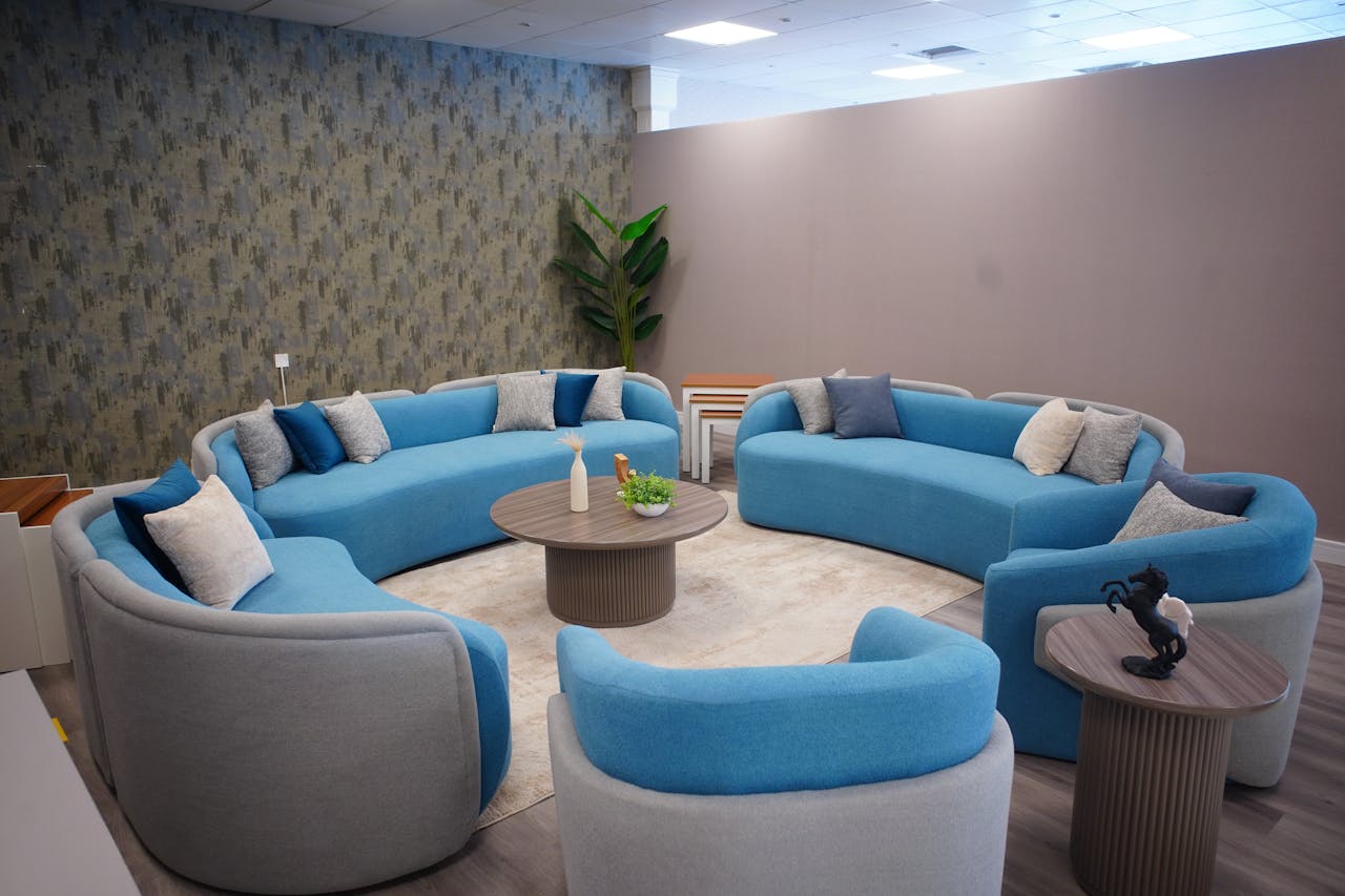 Elegant living area featuring circular blue sofas and warm lighting for a cozy ambiance.